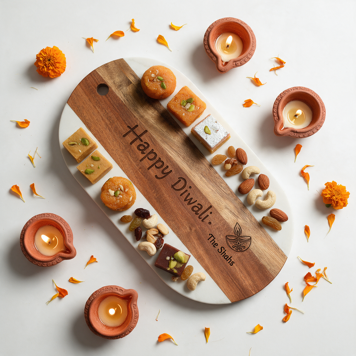 White marble and acacia oval board engraved Happy Diwali The Shahs with mithai and dry fruits
