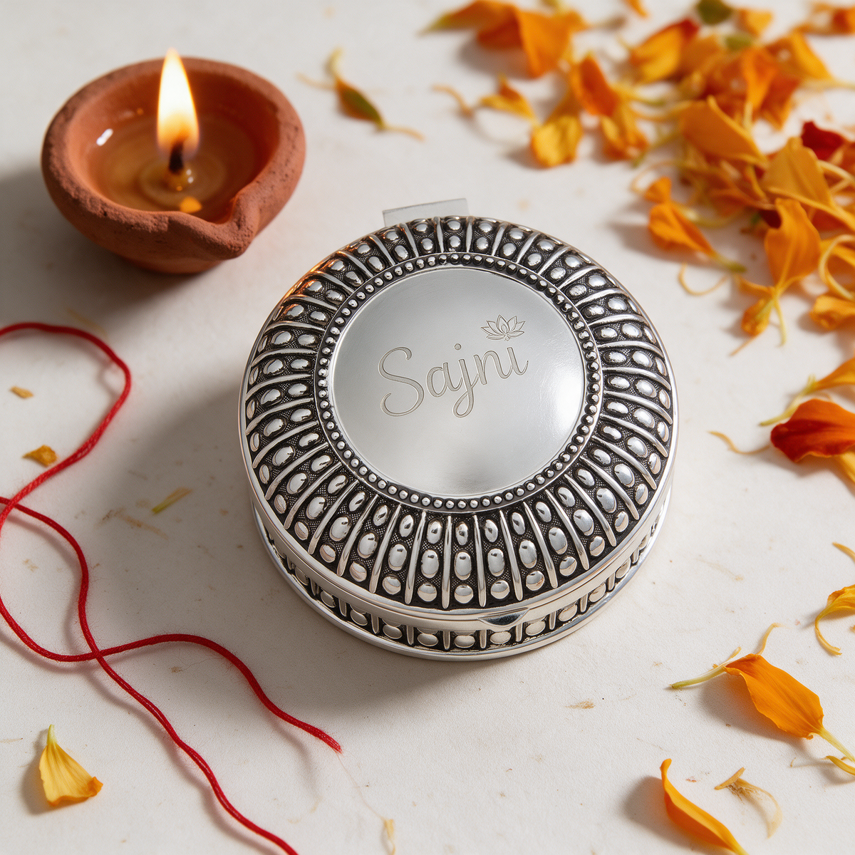 Round silverplated antique-style box engraved Sajni with a small lotus for Diwali
